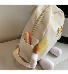 Detail of cute cream canvas backpack showing functional side pocket with lipstick
