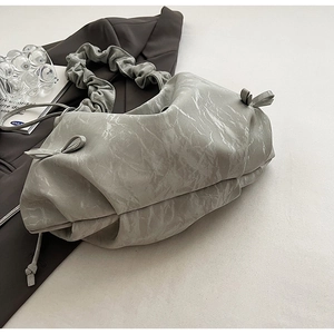 Détail du sac à bandoulière plissé gris avec texture marbrée et petits nœuds