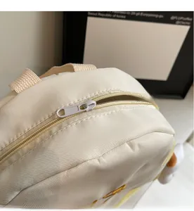 Detail shot of smooth zipper and textured beige canvas fabric on student backpack