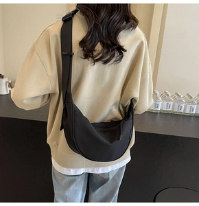 Detail of black waterproof nylon crescent bag with adjustable wide fabric strap