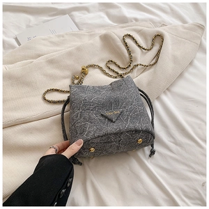 Close-up of marble pattern drawstring bucket bag with gold chain and chic logo