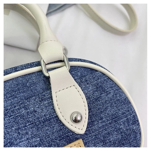 Dettaglio in denim e pelle a contrasto con finiture in metallo argento su una borsa mini