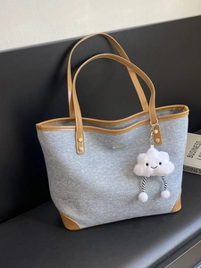 Contrast denim tote bag for women featuring brown leather trim and cute plush charm