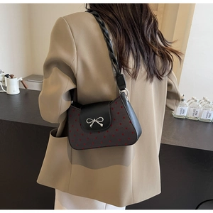 Detailaufnahme der Schleifenschnalle an der schwarz-roten Polka-Dot-Schultertasche
