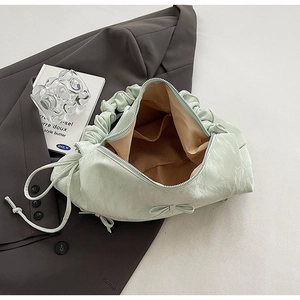 Détail du sac à main plissé vert menthe montrant la doublure, la poche et le nœud élégant
