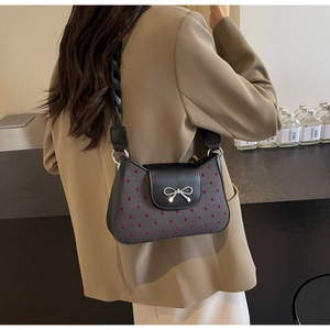 Detail der grauen Stofftasche mit roten Herzmustern und silberner Schleifenschnalle