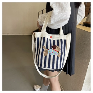 Sac seau en toile à rayures bleues et blanches avec broderie chien sur mannequin