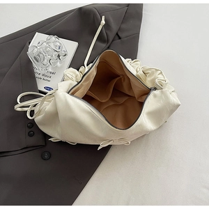 Gros plan de l'intérieur du sac plissé beige avec doublure et poche zippée