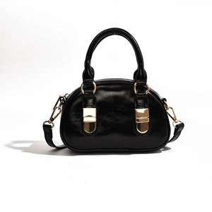 Black glossy bowling bag with gold hardware and removable shoulder strap for women