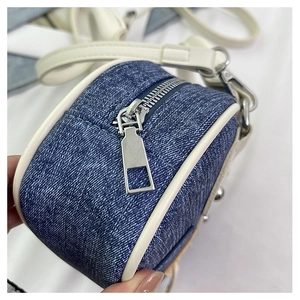 Dettaglio borsa a bauletto in denim a contrasto con zip in metallo argentato lucido