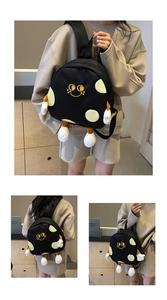 Detail of cute black canvas backpack featuring yellow smiley face and plush limbs design