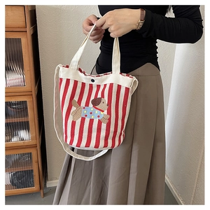 Détail du sac seau en toile à rayures rouges avec broderie de chien mignon