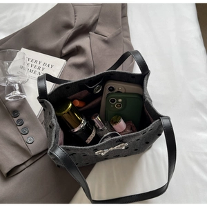 Detail view of canvas bucket bag interior with pink lining and metal bow decoration