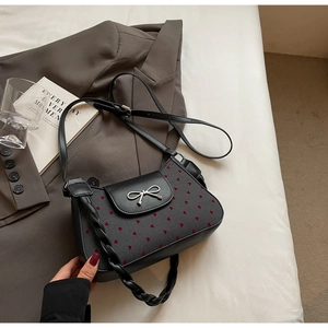 Detail der Schultertasche mit Herzprint, silberner Schleifenschnalle und Webgurt