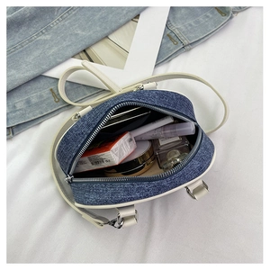 Vista interna della borsa in denim con spazio per trucco e oggetti quotidiani