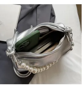 Innenansicht der silbernen Hobo-Tasche mit großem Fassungsvermögen und Perlenkette