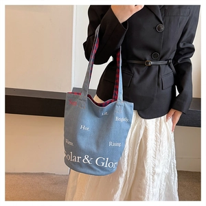 Dettaglio della borsa tote in denim blu con stampa Solar & Glory e fodera a quadri