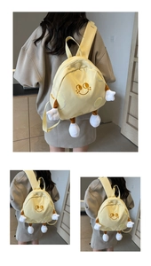 Detail of yellow cartoon backpack with 3D limb accents and cute embroidered smiley face