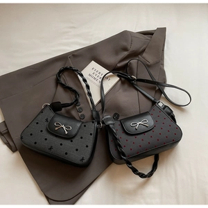Detail von Retro-Unterachseltaschen mit Polka-Dots, Herzmuster und Schleifenschnalle auf Sakko