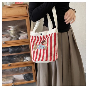 Détail d'un sac fourre-tout en toile à rayures rouges et blanches avec broderie de chien