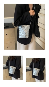 Detail of silver quilted leather bag with metallic chain strap and turn-lock closure