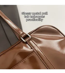 Detail of glossy brown tote bag showing silver metal ring and neat stitching