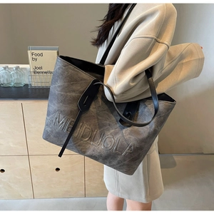 Detail of MEIDUOLA embossed texture on a grey minimalist large capacity tote bag