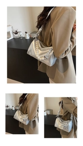 Detail der silbernen Tasche mit Perlengriff und herzförmiger Kettenverzierung