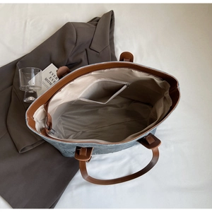 Top-down view of spacious interior of blue canvas tote bag with leather straps