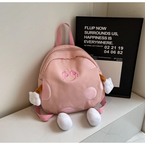 Detailed view of pink cartoon canvas backpack with embroidered smile and 3D plush details