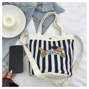 Détail du sac seau en toile rayée avec broderie de chiot mignonne et petit bouton décoratif