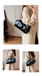 Detail of glossy black patent leather tote bag styled with a beige trench coat