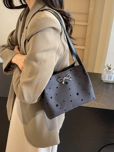Chic black star print underarm bucket bag with silver bow accent for women