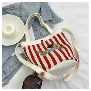Détail du sac seau en toile rayé rouge et blanc avec broderie de teckel mignon
