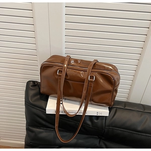 Close-up of vintage brown patent leather handbag with glossy finish and silver hardware