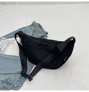 Detail shot of black crescent nylon crossbody bag with adjustable strap and buckle