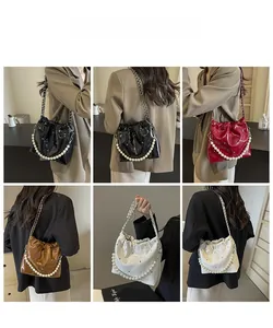 Collage of model wearing pearl and chain bucket bags in black, red, brown, and white