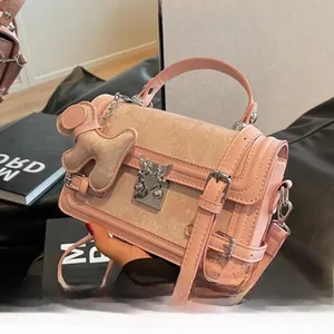 Détail du sac à main vintage rose avec boucle cœur d'ange et pendentif ours en peluche