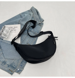 Macro detail of black crescent dumpling bag with drawstring and adjustable strap