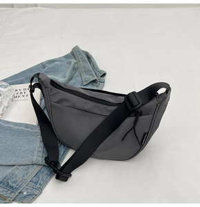 Detail view of dark grey nylon crescent bag with adjustable wide shoulder strap