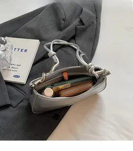 Detailed view of the spacious silver metallic shoulder bag interior with daily essentials