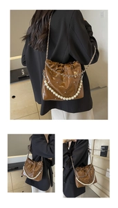 Detail of brown quilted faux leather bucket bag with pearl handle and metal chain strap