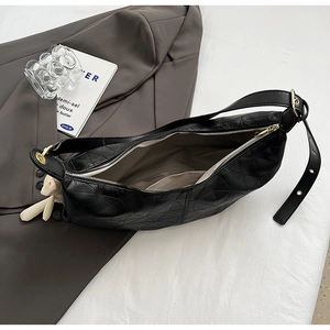 Detail view of black geometric embossed hobo bag with inner lining and scarf decor