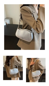 Detail of silver metallic underarm bag with wavy opening and knotted strap detail