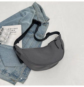 Detailed view of the dark grey dumpling bag with adjustable strap and buckle closure