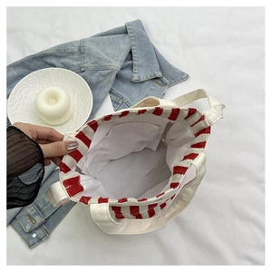 Détail du sac cabas en toile rayé rouge et blanc montrant la poche intérieure et couture