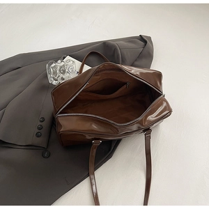 Detailed interior of dark brown shiny leather tote bag with a secure zipper pocket