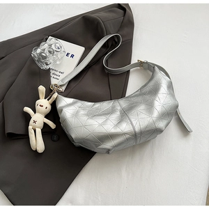 Detail of silver geometric hobo bag with triangle texture and plush rabbit charm