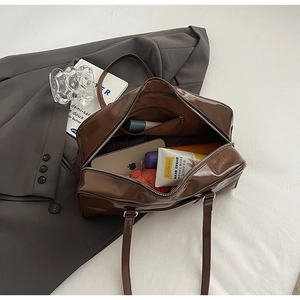 Internal storage detail of brown vintage boston bag showing phone and umbrella capacity