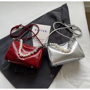 Detailansicht weinroter und silberner PU-Taschen mit Perlenketten und Herzanhängern